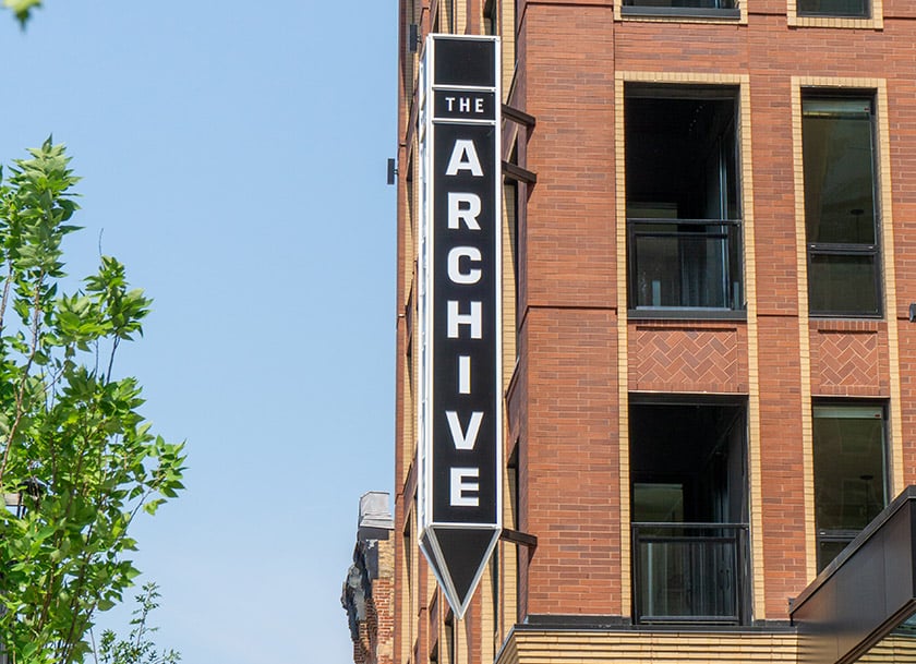 The Archive Residential building projecting sign on brick building exterior
