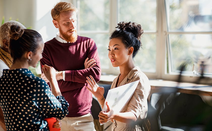 A woman explains her project to a man and woman in an office 