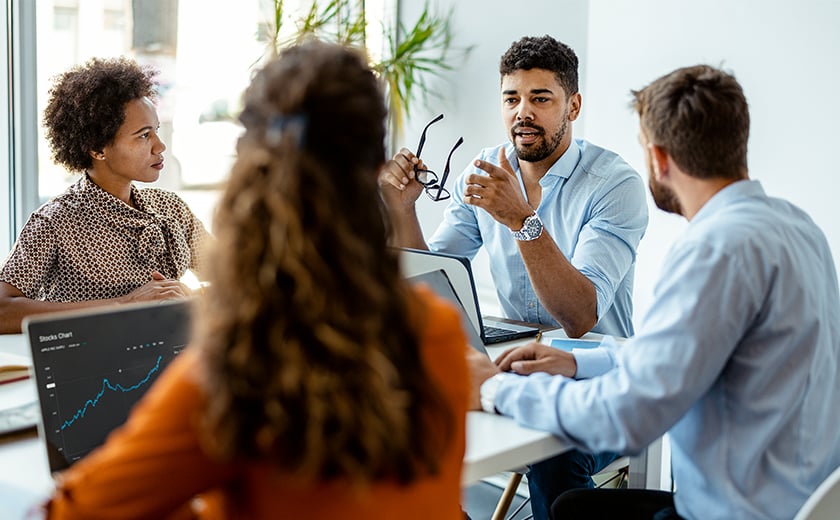 4 employees sitting around a table