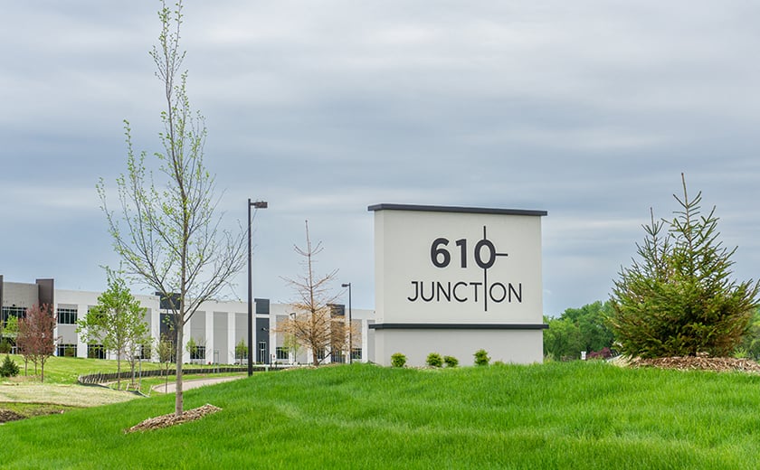 610 Junction monument sign on a grassy hill in front of a building
