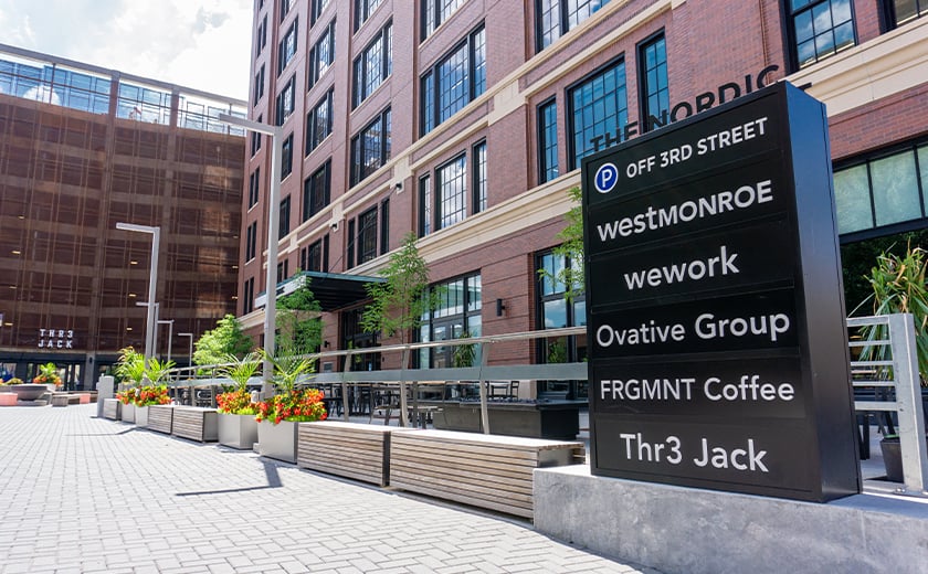 The Nordic, multi-tenant monument sign outside of brick building 