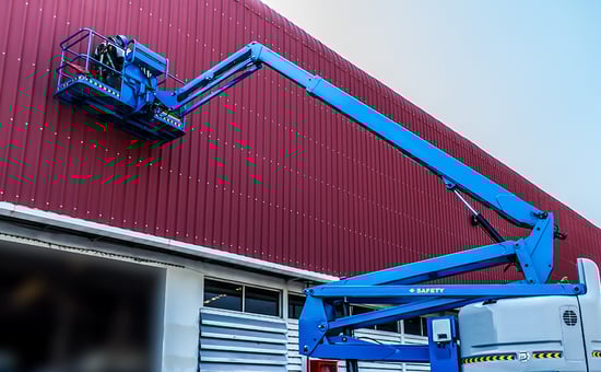 Crane against a building, employee installing a sign